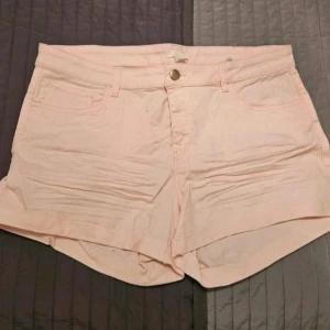 Shorts H&M 44 jeansshorts - Snygga ljusrosa shorts i jeansmaterial med klassisk femficksdesign och knappgylf. Perfekta för varma dagar och har en enkel, stilren look som passar till det mesta. Midjan är normalhög och shortsen har en avslappnad passform  Kan även hämtas I Partille  E5