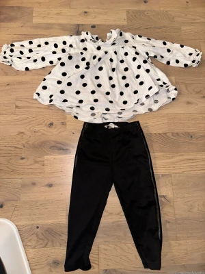 Vit tröja med svarta prickar och med svarta byxor stretch , stl 86 - Säljer ett gulligt set från Newbie i storlek 86. Setet består av en vit tröja med svarta prickar och matchande svarta byxor. Perfekt för dig som gillar lekfulla och stilrena plagg till de små. Mjukt och bekvämt material som passar till vardags.