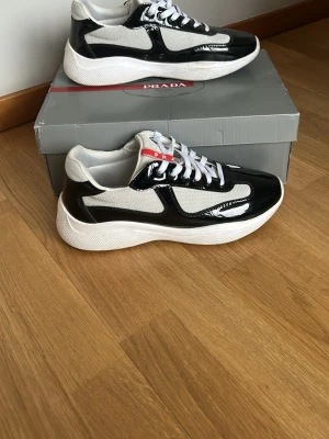 Svart och vita sneakers - Hej jag säljer dessa riktigt stiliga sneakers. Använda fåtal gånger, väldigt bra kvalité!! Ingen skada bara smutsig sula som ni ser på bilden. Väldigt fina detaljer och lyfter en outfit. Sticker ut och passar till mycket🔥 skriv vid frågor eller intresse!😌
