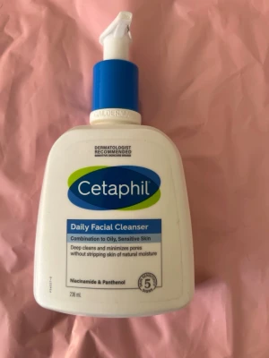 Cetaphil Daily Facial Cleanser 236ml - Cetaphil Daily Facial Cleanser för kombinerad till oljig och känslig hud. Vit plastflaska med blå pump och etikett. Innehåller niacinamid och panthenol, rengör på djupet utan att torka ut huden. Dermatologiskt rekommenderad. Typ 80% kvar !