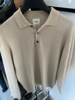 Beige cashmeretröja från John Henric - Snygg beige långärmad tröja från John Henric i 100% cashmere. Tröjan har klassisk krage och tre knappar framtill för en stilren look. Perfekt för dig som gillar mjuka och lyxiga material.