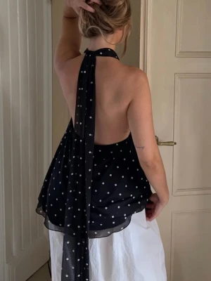Slutsåld halterneck topp från Gina - Säljer en superfin svart halterneck topp med vita prickar och långa knytband i nacken. Toppen är i storlek S och är numera slutsåld på Gina. Den perfekta festtoppen🤩Endast använd två gånger!