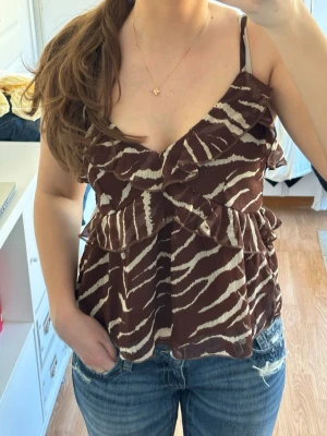 Zebramönstrad topp  - Söt brun zebramönstrad festtopp med smala band och volanger  • från Nelly • storlek 34 • zebramönster • använd två gånger • inga defekter