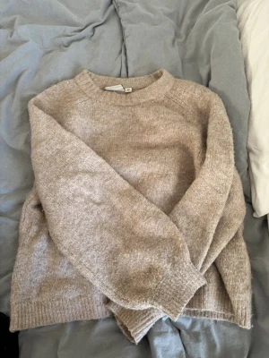 Beige stickad tröja i ullmix - Säljer en mysig stickad tröja med rund halsringning och lång ärm. Tröjan har en avslappnad passform och är tillverkad i en mjuk ullmix som är väldigt skön att ha på sig. Hör gärna av dig vid frågor 💗