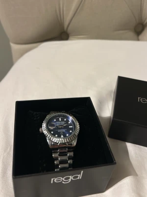 Dm för pris samt info annars 450kr - Stilren klocka med blå urtavla och silverfärgat armband i metall. Klockan har markerade index, datumvisning och en räfflad bezel. Perfekt accessoar för att lyfta din outfit. Dm för mer