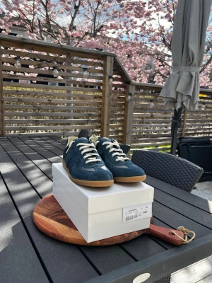 Maison Margiela Gats  - Ett par riktigt snygga Maison Margiela gats I en snygg mörkblå färg i suede och läder. Inköpta från FARFETCH för ett tag sedan och kvitto därifrån finns, bara att skriva. Bara testade en gång inomhus och har inga tecken på användning. Box och skoskydden på bilden följer med. STRL 46