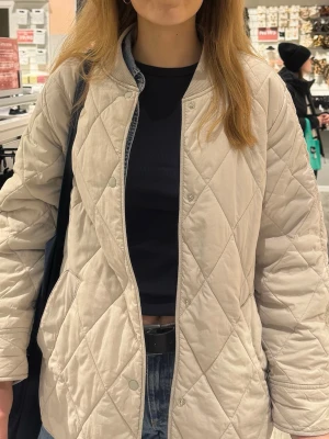 Beige quiltad jacka med tryckknappar - Snygg beige quiltad jacka med rundad krage och tryckknappar framtill. Säljer då den tyvärr inte används så mycket! Storlek S från HM ☺️ 