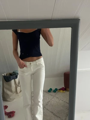 Mörkblå croppad topp med spetskant - Snygg mörkblå croppad topp med korta ärmar och söt spetskant längs den rundade urringningen. Toppen har en tight passform och är perfekt för dig som gillar en enkel men trendig stil.