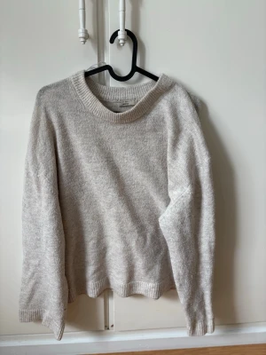 Gina Tricot Premium Quality Knit - Beige/Oatmeal - Size S - A classic and soft knitted sweater from Gina Tricot’s "Premium Quality" line. It comes in a beautiful neutral beige/oatmeal color that goes with everything. The sweater has a slightly dropped shoulder for a relaxed look and a cozy, high-quality feel. It’s perfect for a minimalist "clean girl" aesthetic or as a staple piece in your capsule wardrobe. Very lightweight yet warm. • Brand: Gina Tricot (Premium Quality) • Size: Small (S) • Color: Beige / Oatmeal melange • Condition: Excellent condition