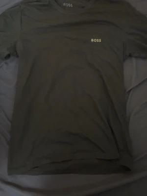Svart t-shirt från BOSS - Snygg svart t-shirt från BOSS med diskret logga på bröstet. Klassisk rund halsringning och korta ärmar. Perfekt basplagg i garderoben med stilren design och mjukt material.