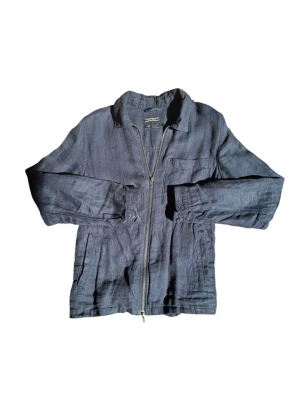 Linne Overshirt  - Stilren mörkblå overshirt  i ett lätt linnematerial. Modellen har klassisk krage, dragkedja framtill, en bröstficka och två sidofickor. Perfekt lager-på-lager-plagg med avslappnad passform och lång ärm.