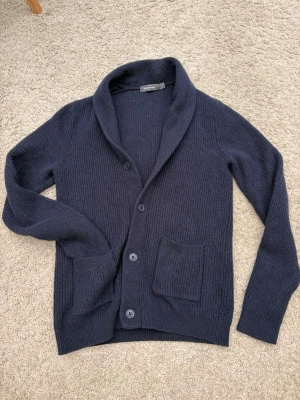 Mörkblå cardigan kofta från Dressman - Säljer en riktigt snygg cardigan kofta från Dressman i marinblå färg. Fint skick och inga skador! Storlek medium men passar som S/M skulle jag säga🤩