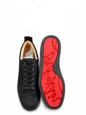 Svarta Louboutin sneakers med röd sula - Snygga svarta sneakers från Christian Louboutin i mocka med klassisk röd signatursula. Lågt skaft, svarta skosnören och diskreta metalldetaljer vid snörningen. Perfekta för dig som vill sticka ut med exklusiv streetstyle. Kommer med skopåsen.