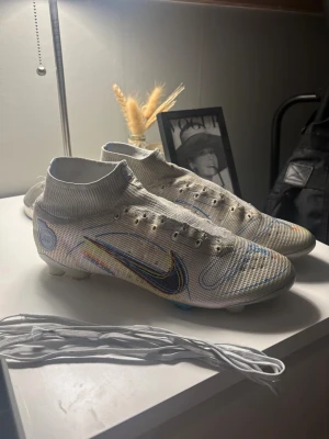 Nike Mercurial Superfly Elite 8 FG - Säljer ett par Nike Mercurial Superfly Elite 8 FG. Använda en hel del - finns därmed hål i strumpan och tydliga tecken på slitage. Såklart följer snören med, men har tyvärr inte kartongen kvar 🙃 snörena är lite svåra att få i, så något köparen får lösa. Storlek:44