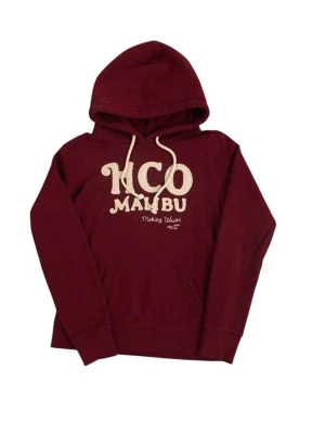Vinröd hoodie från Hollister sällsynt” - Snygg vinröd hoodie från Hollister med stor broderad text 'HCO MALIBU' på bröstet och klassisk känguruficka. Hoodien har dragsko i huvan och är gjord i mjukt bomullsmaterial. Perfekt för en avslappnad och trendig look.