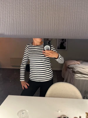 Randig långärmad topp i bomull - Snygg långärmad topp med marinblå och vita ränder. Klassisk rak passform och rund halsringning. Tillverkad i mjuk bomull, perfekt för en avslappnad och stilren look.