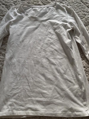 Vit långärmad topp från Asos - En basic vit långärmad topp från basic you med rund halsringning. Tillverkad i mjuk bomull, perfekt att styla lager på lager eller bära som den är. Enkel och stilren design som funkar till det mesta.