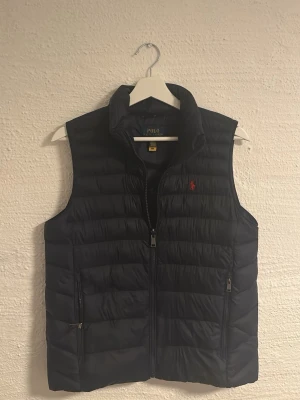 Svart dunväst från Polo Ralph Lauren - Helt ny polo Ralph lauren väst i färgen mörk blå. Passar Xs och är köpt för 1600kr