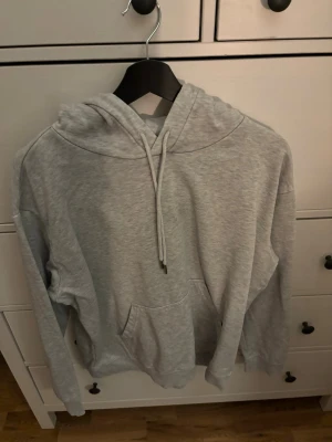 Ljusgrå hoodie - En ljusgrå hoodie med huva och fram ficka. Köpt på HM i storlek M. 
