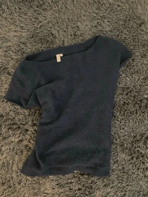 Mörkblå offshoulder topp - Mörkblå topp från Nelly med offshoulder-design och kort ärm. Enkel och stilren modell som passar perfekt till jeans eller kjol. Mjuk och bekväm, perfekt för dig som gillar en avslappnad men trendig look.