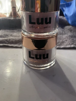 Luu akrylpulver Universal & Warm Pink - Två burkar akrylpulver från Luu Acrylic System i färgerna Universal Pink och Warm Pink. Perfekt för att bygga och forma naglar. Kommer i genomskinliga burkar med roséguldslock och rymmer 56g vardera. Använda till ett sett (båda färgerna)