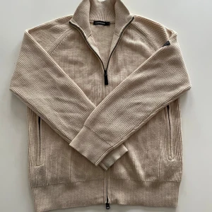 Beige stickad kofta från J.Lindeberg - Säljer nu en fet Beige stickad kofta från J.Lindeberg med ribbat mönster. Perfekt till höst och vinter. Använd max 2 gånger eftersom den är för stor för mig. Inga skador eller missfärgningar den är i nyskick.                              Pris går att diskutera vid snabb affär 
