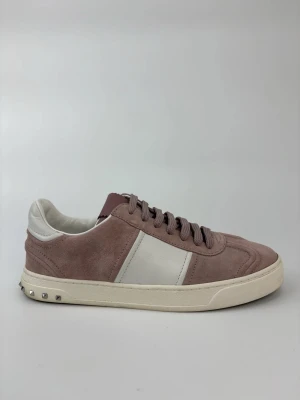 Valentino flycrew skor - Snygga sneakers i rosa mocka med vita läderdetaljer och vit sula. Skorna har coola nitar på hälen och klassisk låg profil. Perfekta för dig som vill ha en stilren men ändå unik look.