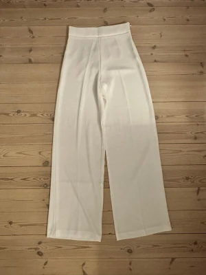 Vita vida byxor med hög midja - Snygga vita byxor med hög midja och vida ben. Aldrig använda. 