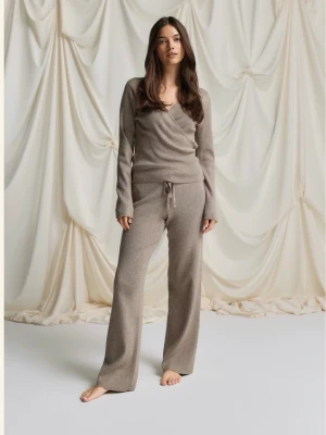 Beige loungewear-set med omlottopp - Mysigt loungewear-set i beige med långärmad omlottopp och vida byxor med dragsko i midjan. Setet har en avslappnad passform och perfekt för hemmadagar eller chillkvällar. Knappt använd 