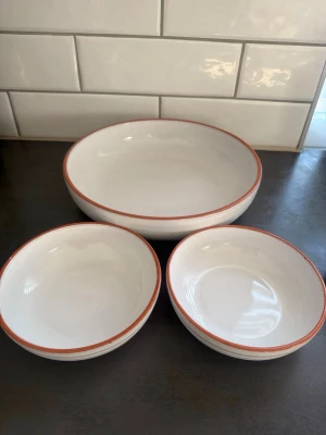 Jamie Oliver vita skålar med röd kant - Tre snygga skålar från Jamie Oliver i vitt porslin med en röd kant. Perfekta för frukost, snacks eller sallad. Skålarna har en rund form och stilren design som passar i de flesta kök.