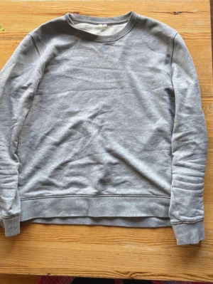 Grå basic sweatshirt i bomull arket - Enkel och stilren grå sweatshirt i mjuk bomull. Tröjan har rund halsringning, långa ärmar och ribbade muddar vid ärmslut och nederkant. Perfekt för en avslappnad och casual look.