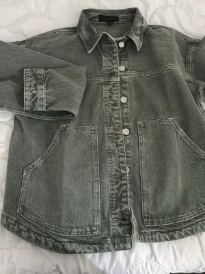Grön overshirt i denim från Zara - Snygg grön overshirt från Zara i denim med klassisk krage, stora framfickor och knäppning framtill.