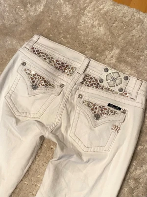 Miss Me jeans - Säljer ett par supersnygga äkta & vintage Miss Me jeans med guld och silver detaljer🪩 Har fler Miss Me jeans +annat på min profil💗 Innersömmen (=jeansstorleken) är 29 tum. Kan inte välja detta som storleksalternativ men skulle säga att dessa är storlek S. Swipa bilder för att se mått, detaljer och märket :) På vänstra benet finns det väldigt små fläckar