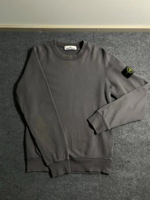 Stone Island – Grey Sweatshirt (S) - Classic and timeless Stone Island sweatshirt in elegant grey. Size S, length 65 cm, width 50 cm – a comfortable fit with a clean silhouette. The sleeve features the iconic Stone Island compass badge, symbolizing quality and innovation in Italian design.  ✅ Condition: Excellent – no stains, no damage 💯 Authenticity: 100% genuine, can be verified easily on certilogo.com 📦 Shipping: Sent immediately after purchase – fast and reliable delivery!  This sweatshirt represents Stone Island’s signature