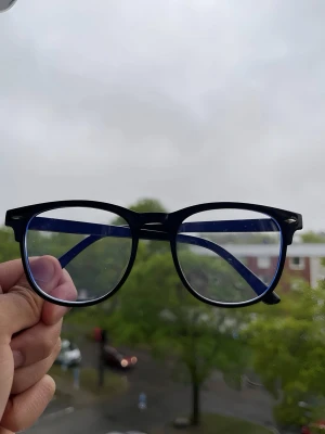 Chrome heart style glasses  - Snygga glasögon med svart båge och blå insida på skalmarna. Runda, stora glas och klassisk form som passar till många stilar. Tillverkade i plast för en lätt och bekväm känsla. Perfekt accessoar för dig som vill ha en trendig look.  Blåljusglasögon som skyddar ögonen och minskar trötthet från skärmar. ( bra att köpa om du är på mobilen eller andra skärmar ofta ) 