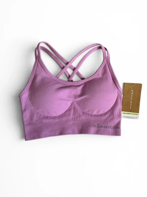 Lila sport-bh från Röhnisch - Sport-bh i smoky grape från Röhnisch med smala korsade axelband i ryggen. Bh:n är sömlös med ribbad nederkant och har en mjuk, stretchig känsla. Säljer på grund av att köpt i fel storlek. 