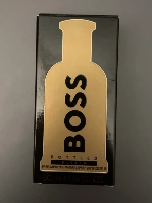 BOSS Bottled Elixir Parfym 50ml - BOSS Bottled Elixir är en intensiv parfym från Hugo Boss. Flaskan är svart med gulddetaljer och har en elegant, rundad form. Förpackningen är svart med guld och har en stilren design. Volymen är 50 ml varav 45 ml är kvar i flaskan.