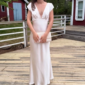 Champagnefärgad balklänning - Säljer min balklänning!! Lång champagnefärgad satinklänning perfekt för bal💞jättefin v-ringning och öppen rygg med detalj. Köpt här på Plick och då bara använd en gång☺️☺️så i mycket bra skick! Jag är 164 men har klackar på bilderna så blir ca 170 som referens. Skriv vid funderingar eller om ni vill ha fler bilder 💞💞