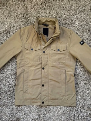 J.Lindeberg field jacket - J.Lindeberg field jacket som är i ett mycket fint skick! Använd ett par gånger och finns något enstaka saker  men absolut inget som syns vid användning. Mycket träsnitt jacka och stor efterfrågan! Nypris 4000kr | mitt pris 2499kr| skriv vid frågor eller funderingar! 