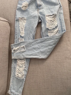 Ljusa jeans från Dr Denim - Säljer ett par ljusblå jeans från Dr Denim. Jeansen har klassisk femficksmodell och raka ben. Tillverkade i bomull för en skön och avslappnad look. En av böltöglorna har lossnat, ses sista bilden. Storlek: 25/30 (midja 25 och längd 30)