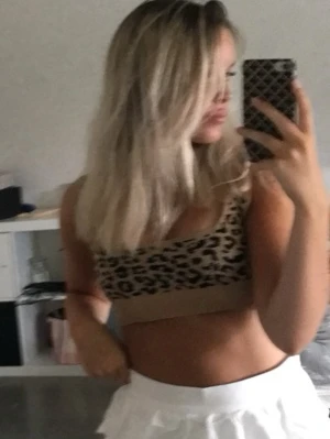 Leopardmönstrad ribbad linnetopp - Snygg ribbad linnetopp i beige med svart leopardmönster. Toppen har breda axelband och är croppad i modellen. Perfekt att styla till högmidjade jeans/konstumbyxor. 