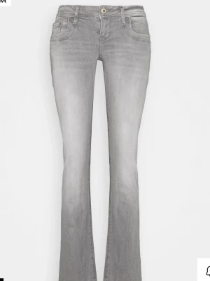 Grå bootcut jeans med låg midja LBT - Snygga grå jeans med bootcut passform och låg midja. Klassisk femficksmodell med knappgylf och subtila slitningar för en avslappnad look. Perfekta för dig som gillar en retrostil och vill ha ett par jeans som sticker ut.