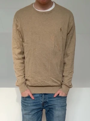 Beige tröja Ralph Lauren  - Säljer en beige stickad Ralph Lauren tröja i färgen beige! Tröjan har tyvärr förlorat lappen i nacken men de är inget som påverkar själva tröjan utifrån! Den sitter i strl M och hör gärna av er vid frågor elr funderingar!!