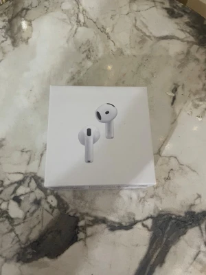 AirPods 4 trådlösa hörlurar - Säljer ett par vita  AirPods 4 utan laddningsetui. Hörlurarna har en stilren och modern design i blank plast och levereras i originalförpackning. Perfekta för dig som vill ha trådlös frihet och grym ljudkvalitet till mobilen eller datorn.