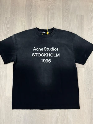 Svart Acne Studios t-shirt - Cool svart t-shirt från Acne Studios med tryck 'STOCKHOLM 1996' på bröstet. Klassisk passform med rund hals och korta ärmar. Perfekt till jeans eller shorts för en avslappnad look. Frakt inom 24h från köp. Skriv vid minsta fundering☺️