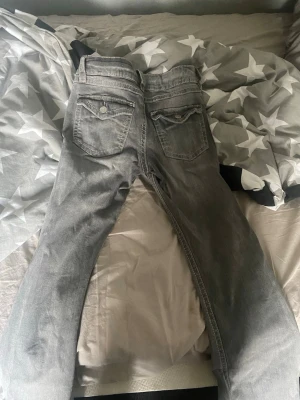 Gina Grå jeans med fickdetaljer - Går längst ner till 199kr. Säljer ett par grå jeans från gina  snygga fickdetaljer bak. Jeansen har klassisk femficksmodell och ljus tvätt som ger en avslappnad vibe. Perfekta till en casual outfit och passar till det mesta i garderoben.