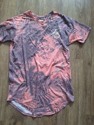 Rosa och lila t-shirt från Siksilk - Snygg t-shirt från Siksilk i rosa och lila med ett unikt mönster och logga på bröstet.