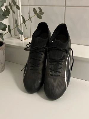 Puma ultra fotbollsskor - Hej, säljer nu detta par fotbollsskor i mycket bra skick där det endast är dobbarna som är lite slitna. Skorna funkar lika bra på gräs som på konstgräs(FG/AG). Puma passar dig som vill ha otroligt sköna skor där du också flyger fram på planen då skorna är mycket lätta. Vid frågor är det bara att höra av sig. Nypris 2499| Mitt pris 399