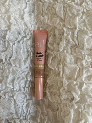 e.l.f. Halo Glow Beauty Wand Highlighter - Säljer en e.l.f. Halo Glow Beauty Wand Highlighter i färgen Champagne. Kommer i en smidig tub med applikator och ger ett snyggt glow till huden. Endast använd ett fåtal gånger 