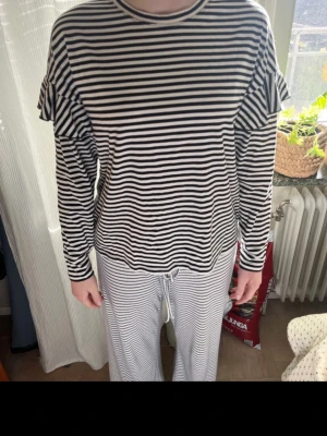 Randig långärmad tröja med volangärm - Säljer en svartvit randig tröja med volangdetaljer i ärmen! Fint skick